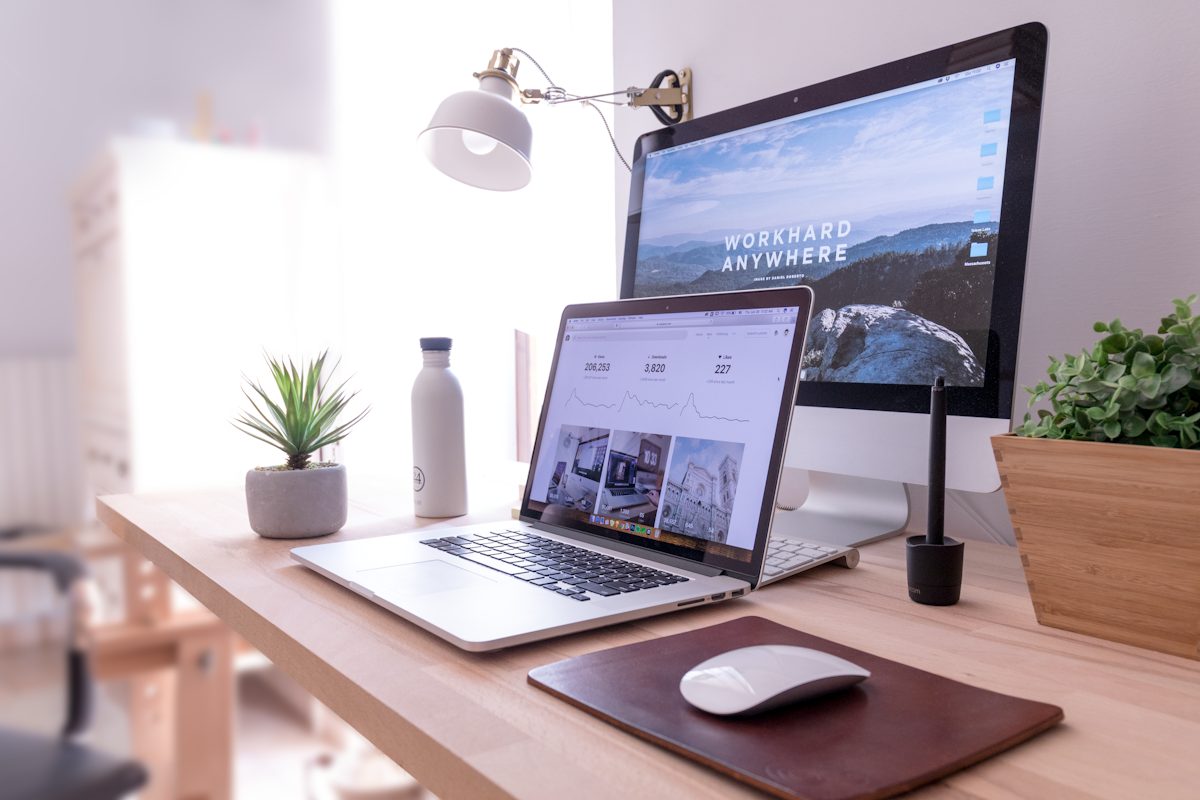 A laptop, monitor and mouse on a mouse pad illustrating a keyboard and mouse layout kept close together